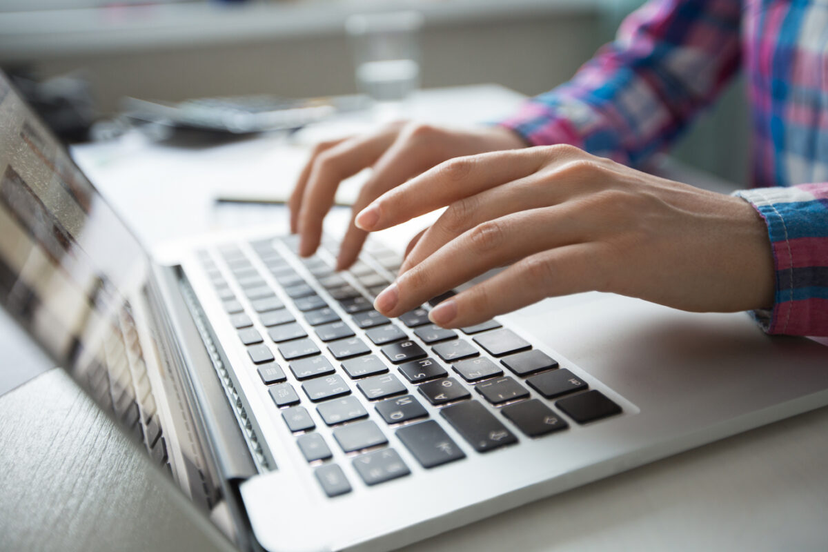 cropped view hands typing laptop