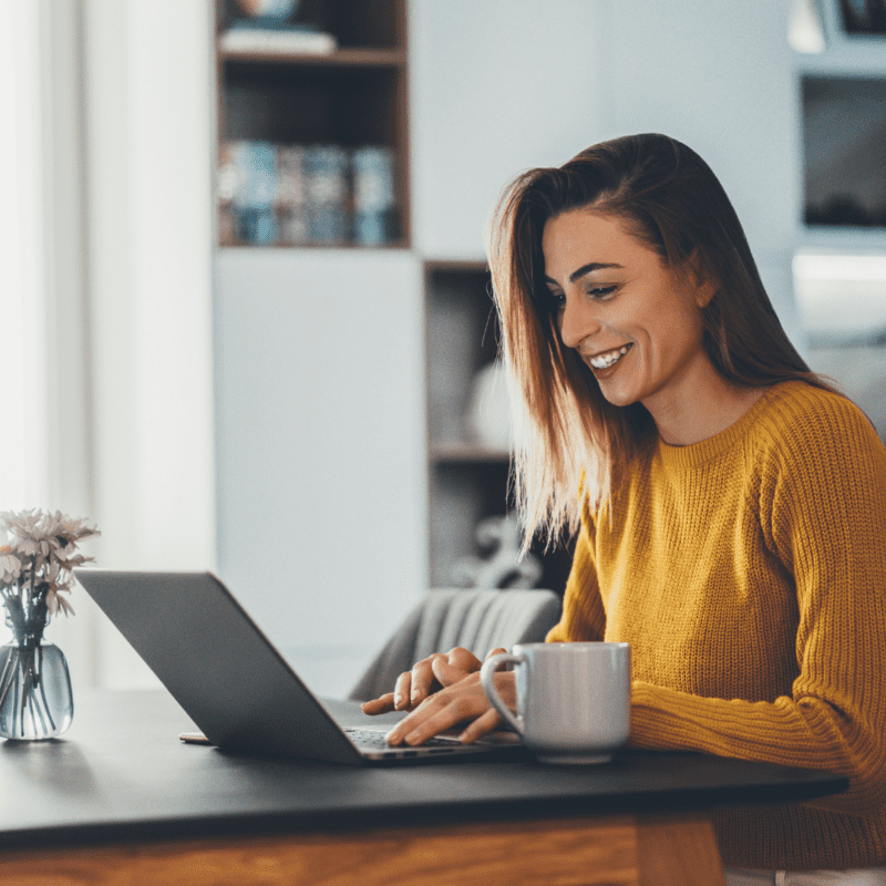 Blije vrouw aan het werk achter haar werkplek met Desktop 365