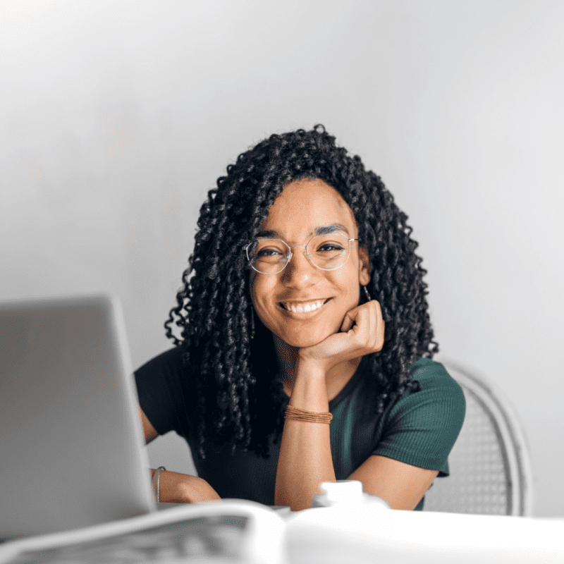 Blije vrouw aan het werk achter haar online werkplek