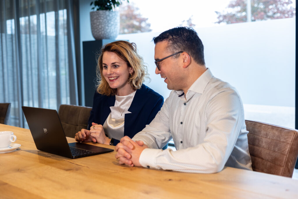 Twee collega's bespreken aan een laptop wat er gebeurt met het mailaccount van een ex-werknemer